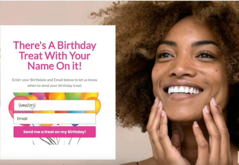 Smiling person with curly hair touching their face alongside a form for a birthday treat. Text reads: "There's a Birthday Treat With Your Name On It!"